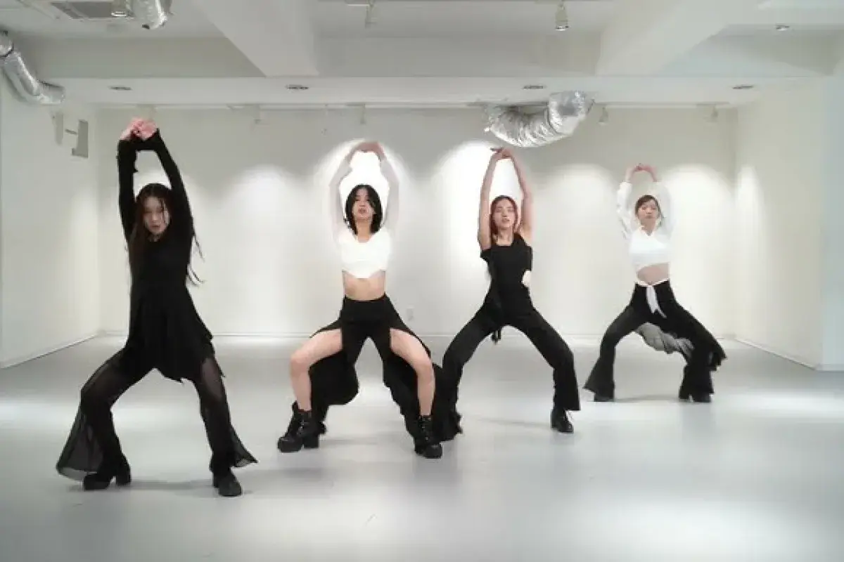 K-pop group rehearsing dance routine in mirrored studio