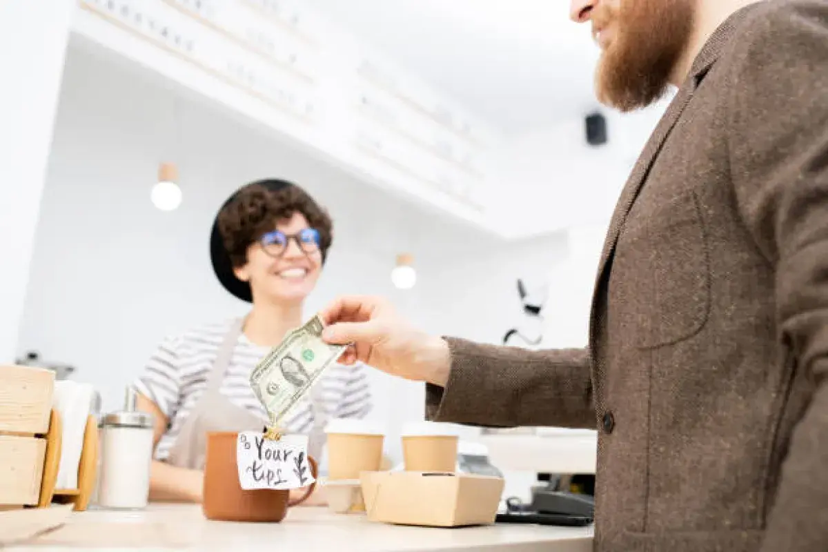 Coffee shop customer leaving a tip for the barista.