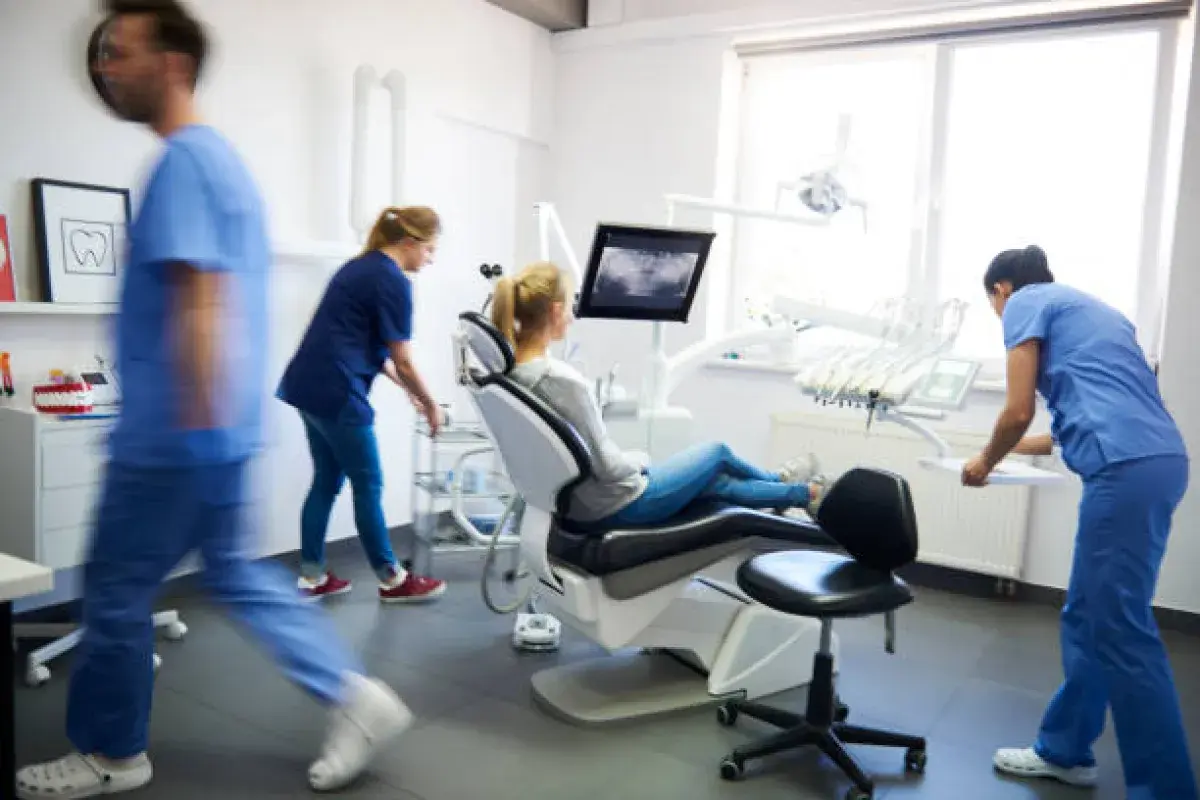 Medical Assistant Helping Patient In Clinic