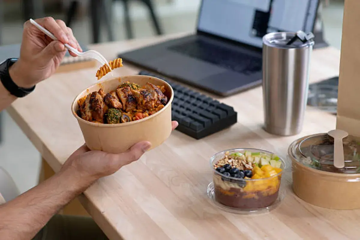 Office employee eating a very large American takeout lunch