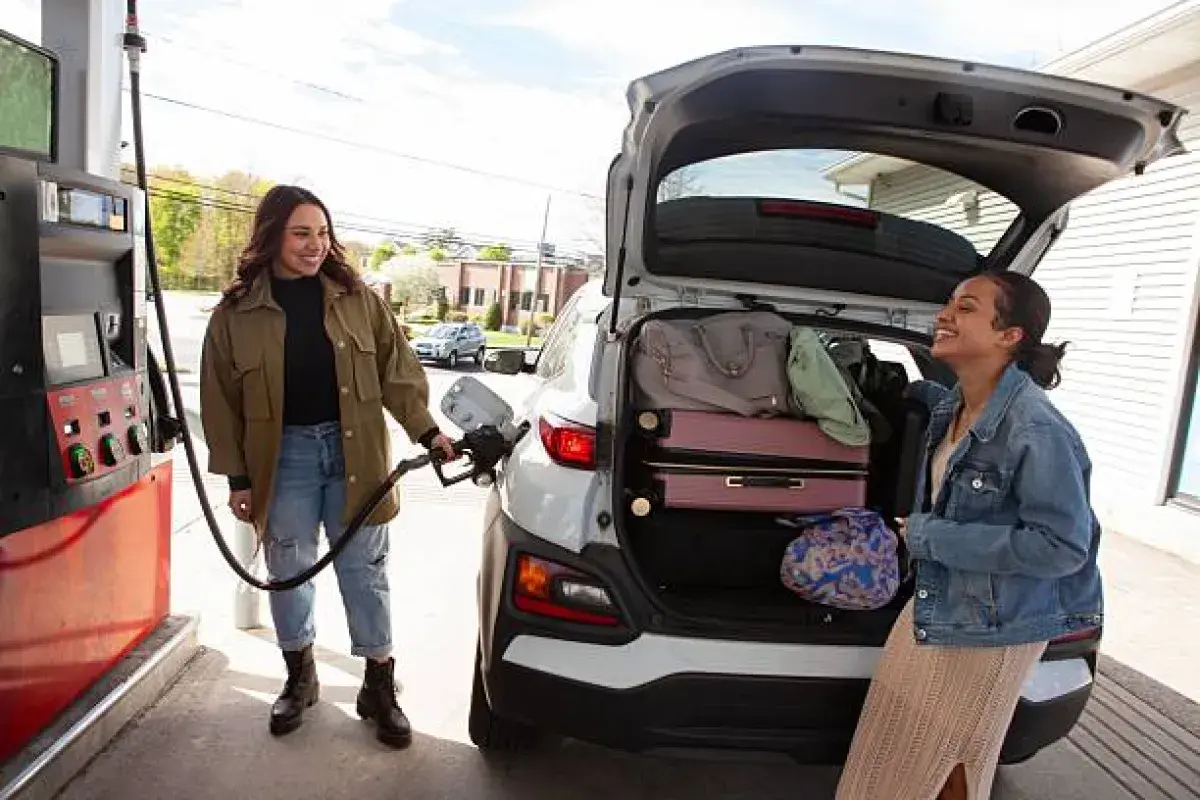 American family refueling their vehicle amid changing gas prices.