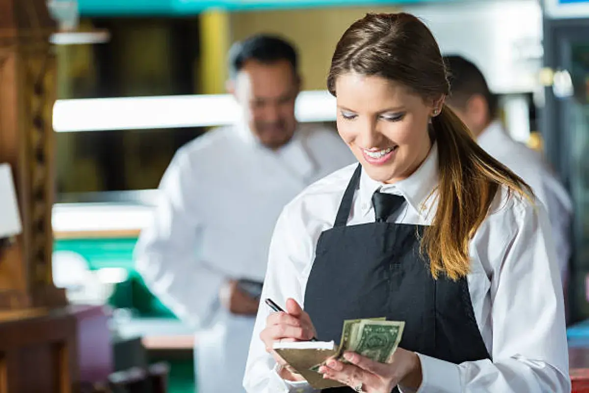 American restaurant server calculating a customer’s tip.