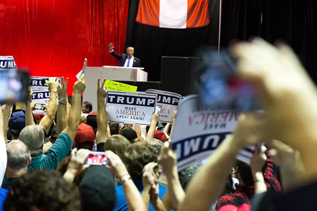 Donald Trump waving to supporters at a rally