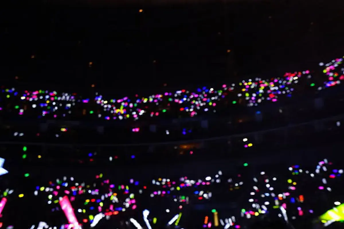 K-pop concert audience forming a sea of glowing lightsticks