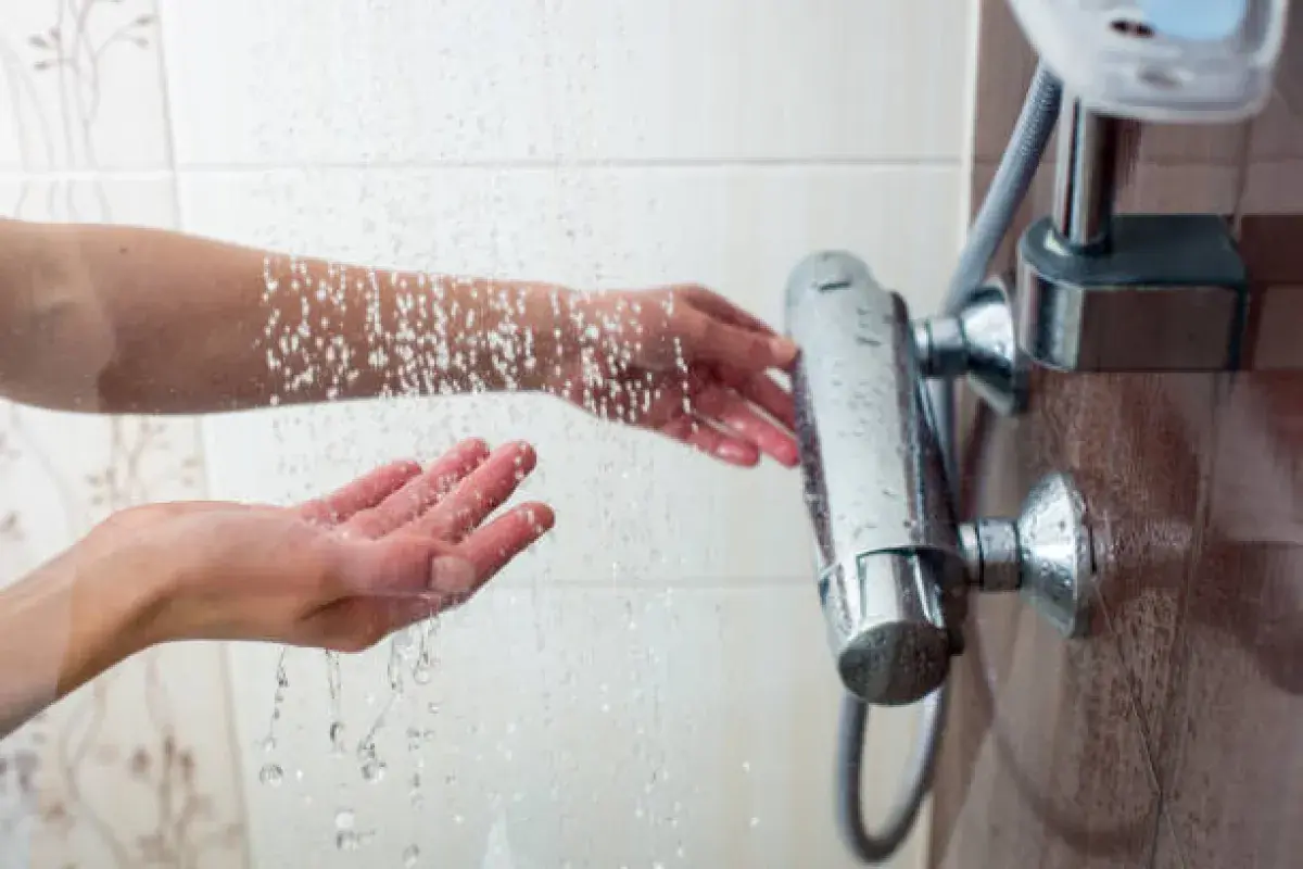 Adjusting water temperature in a warm steamy bathroom