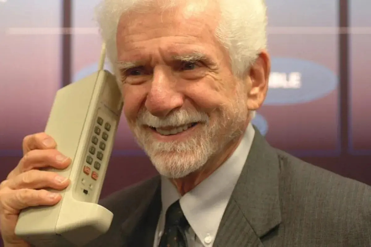 Martin Cooper holding the first handheld mobile phone