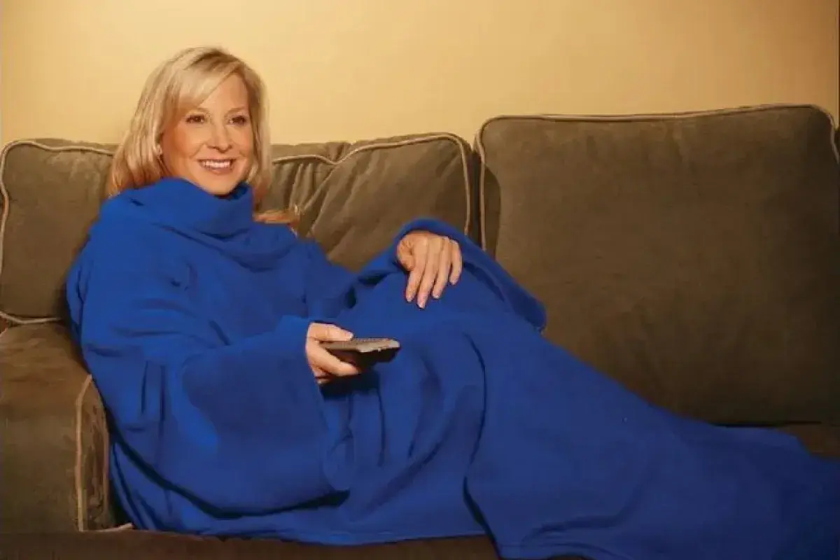 People laughing together in sleeved blankets
