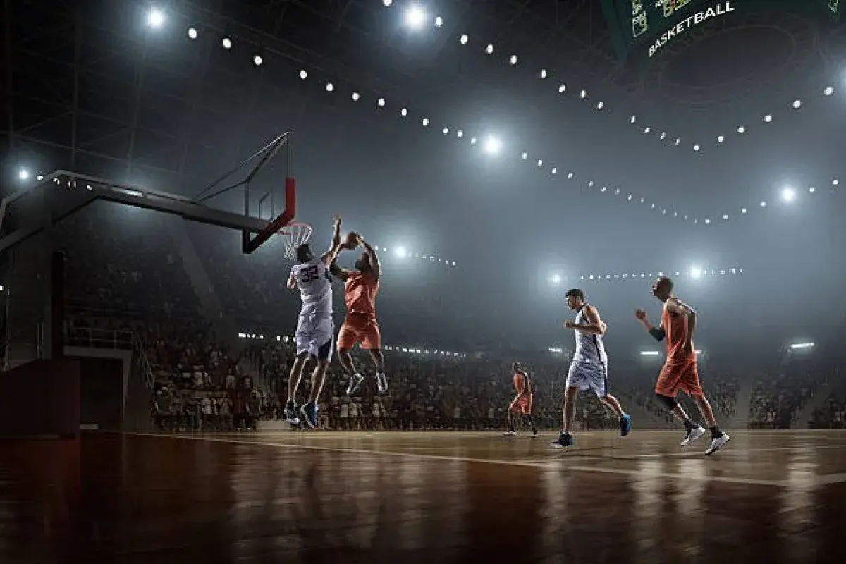 Basketball player executing slam dunk during sold out NBA game