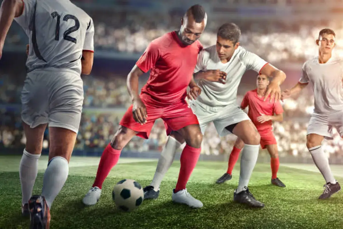 Soccer players battling for ball in front of massive stadium crowd