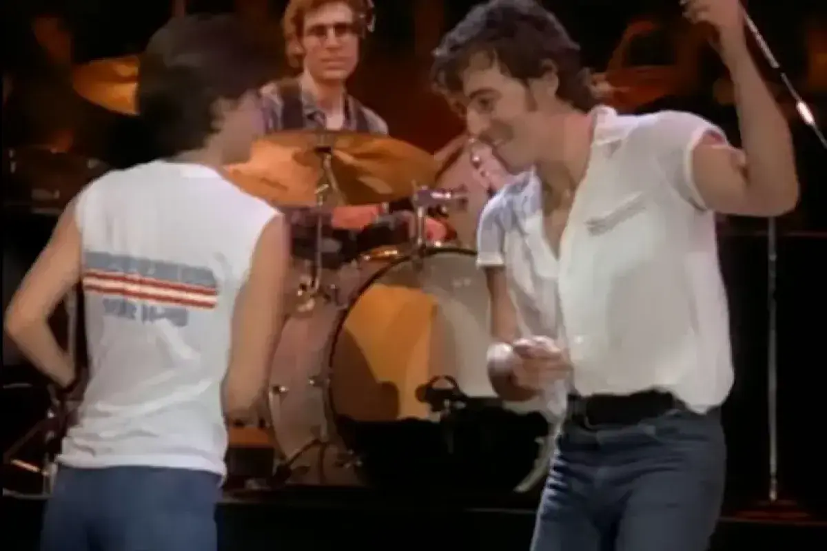 Bruce Springsteen dancing energetically during a live performance