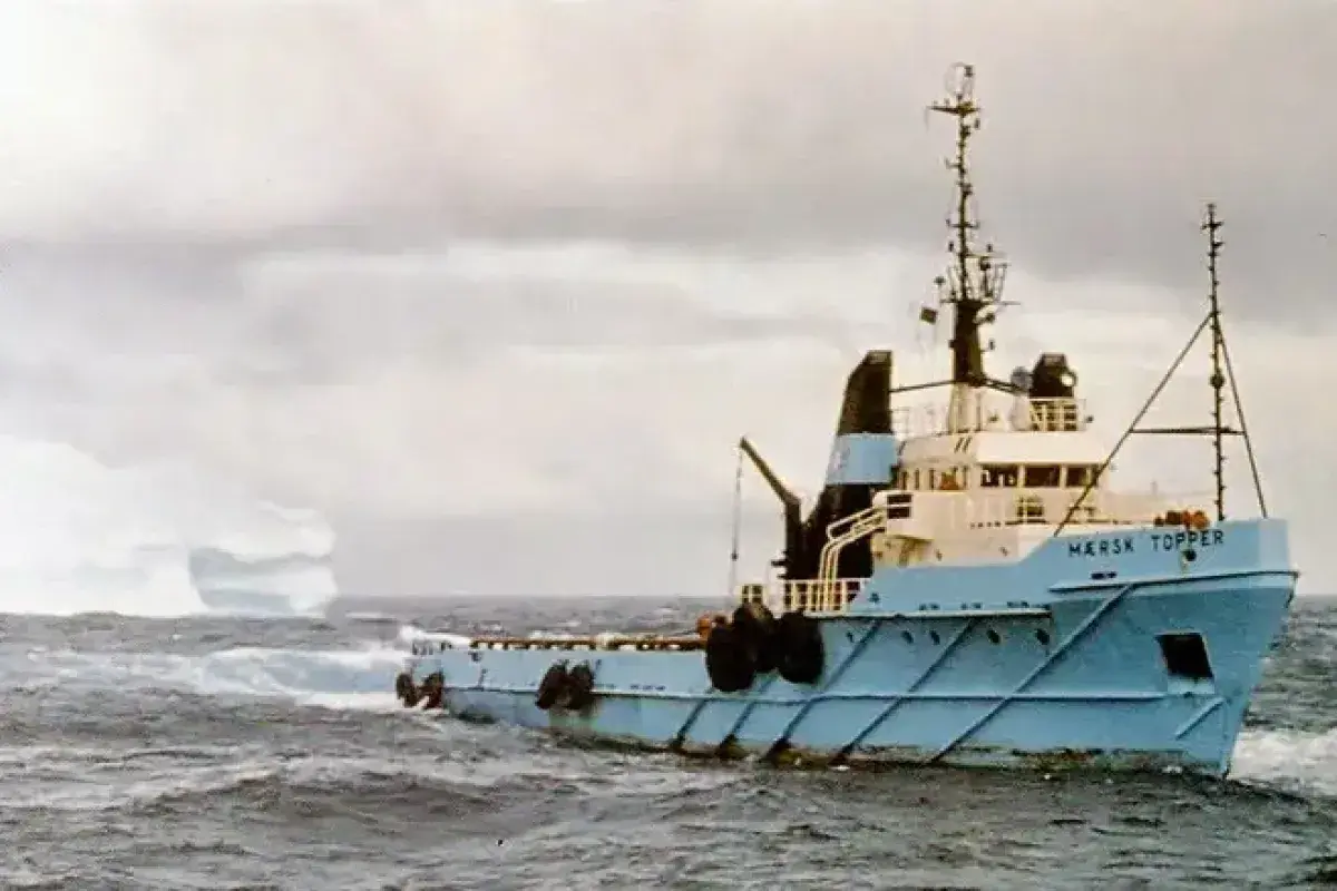 Tugboat guiding an iceberg away from an oil platform