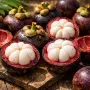 Fresh Purple Mangosteens Opened to Reveal Juicy White Segments on a Tropical Table