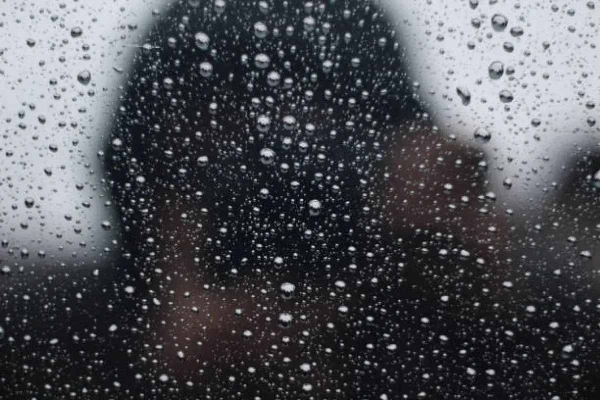 Raindrops on a window reflecting memory and quiet introspection.