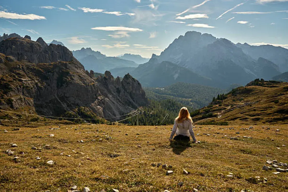 Person sitting quietly in nature, looking out