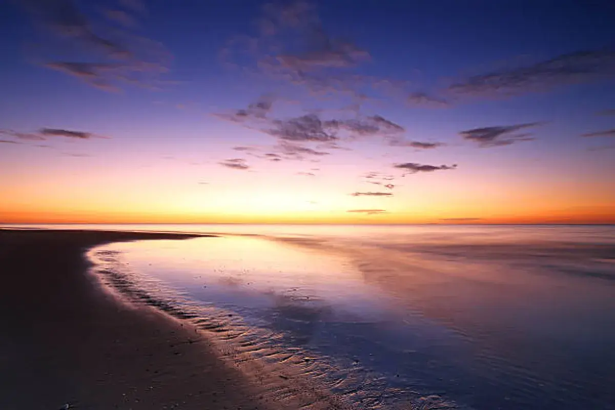 Sunset over a calm shoreline, symbolizing mental peace and acceptance