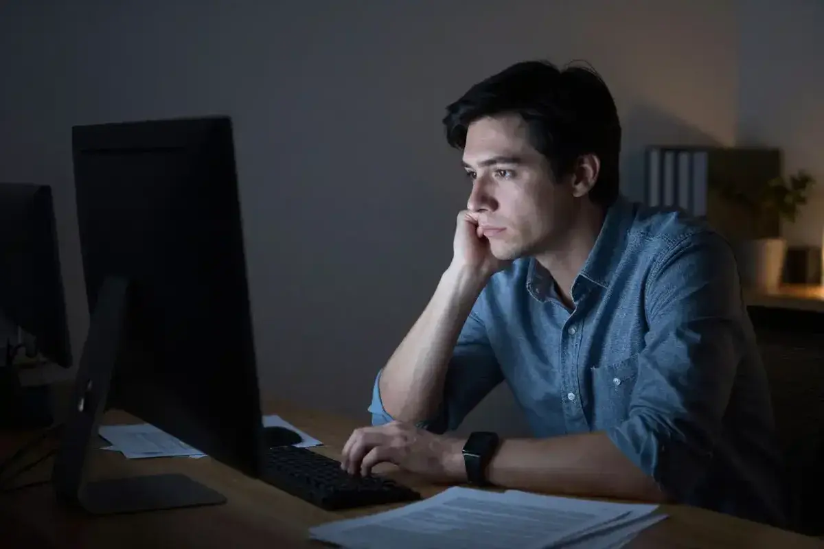 Professional staring blankly at computer screen showing emotional detachment from work