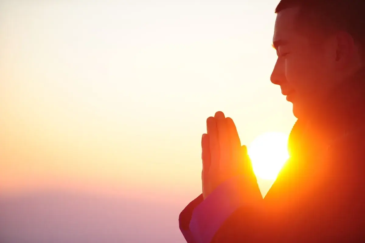 man praying with sunrise background