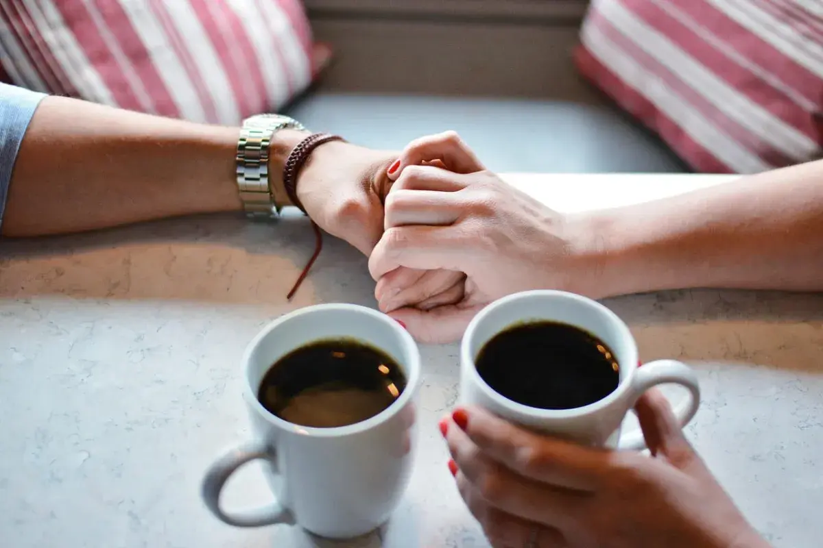 couples hands with cup of coffee 