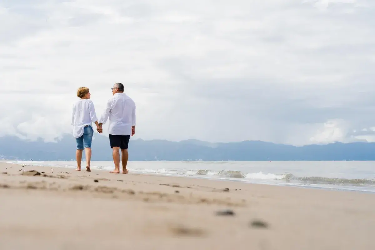 older couple walking at the beach