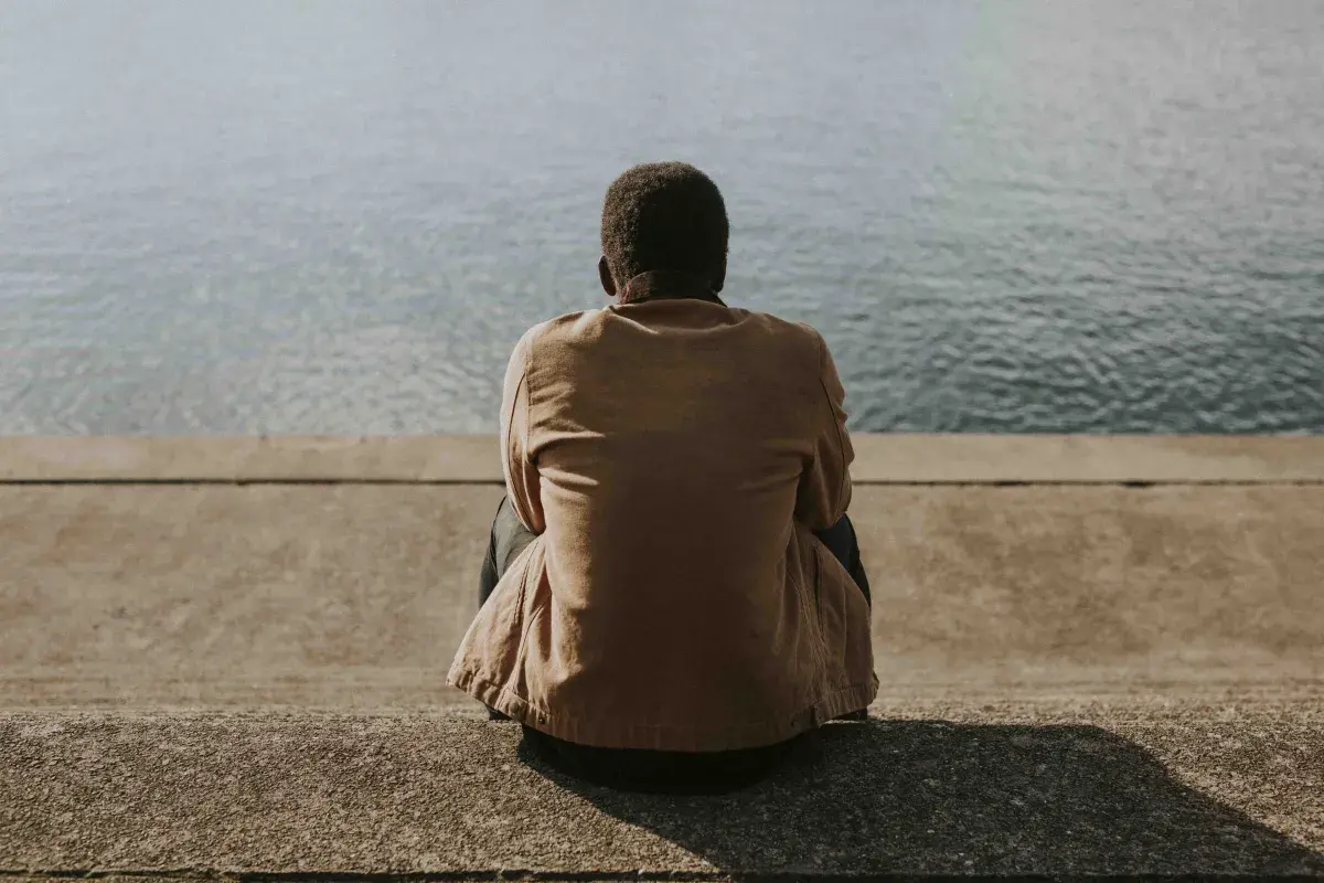 black-man-sitting-by-water