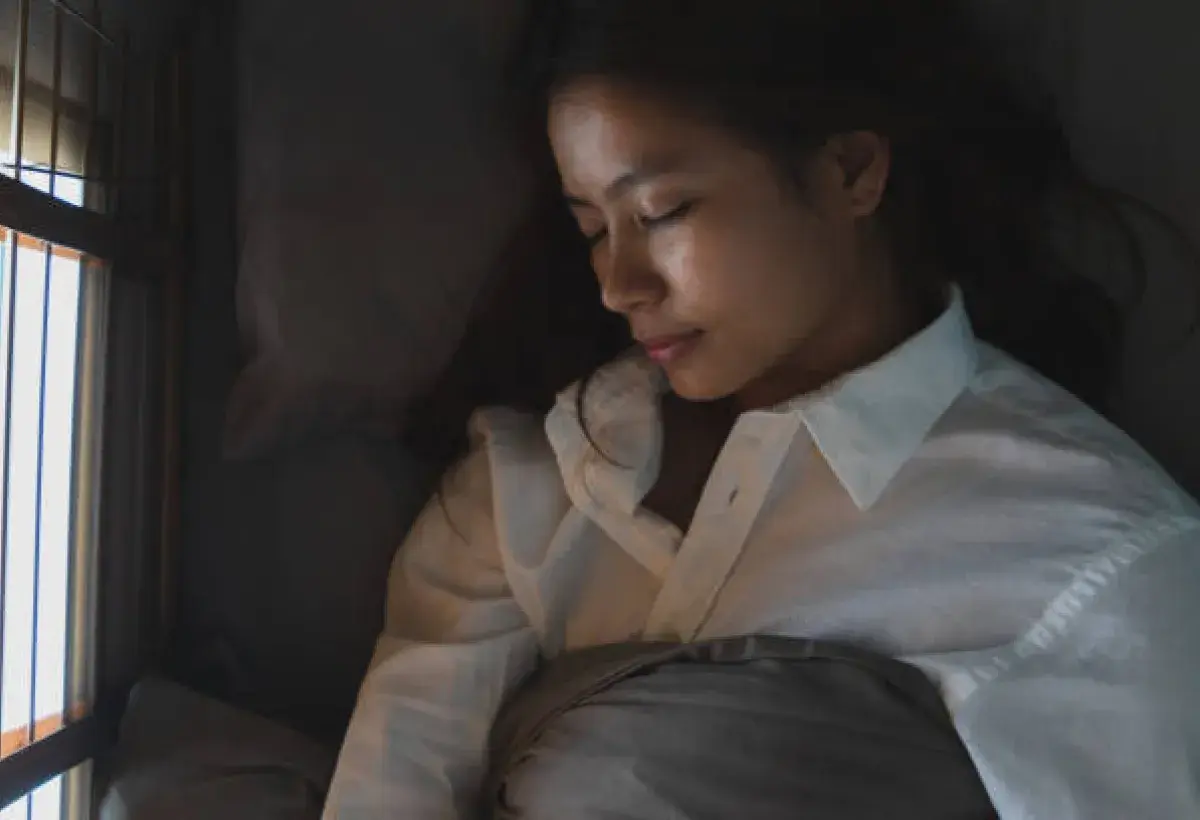 Woman sleeping on a silk pillowcase to enhance overnight skin repair