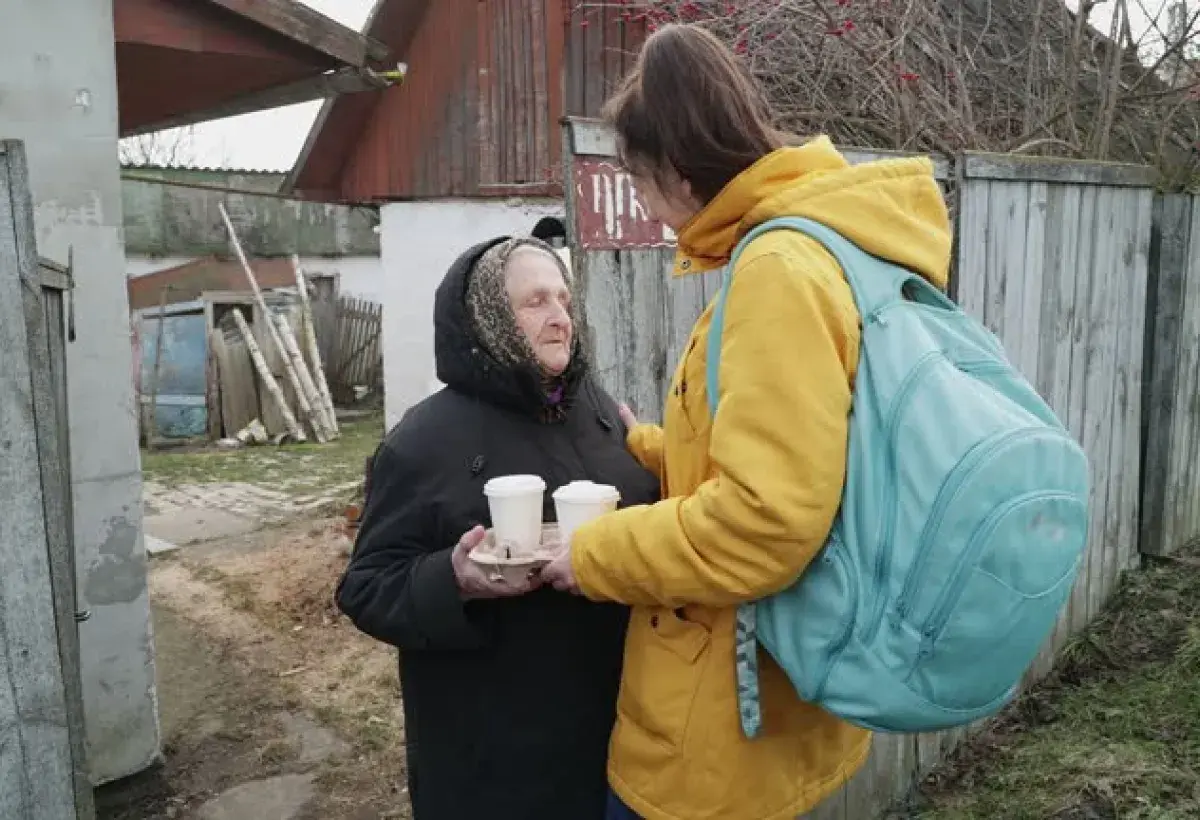 Daughter caring for elderly parent in a developing country home.