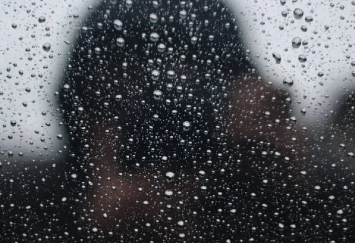 Raindrops on a window reflecting memory and quiet introspection.