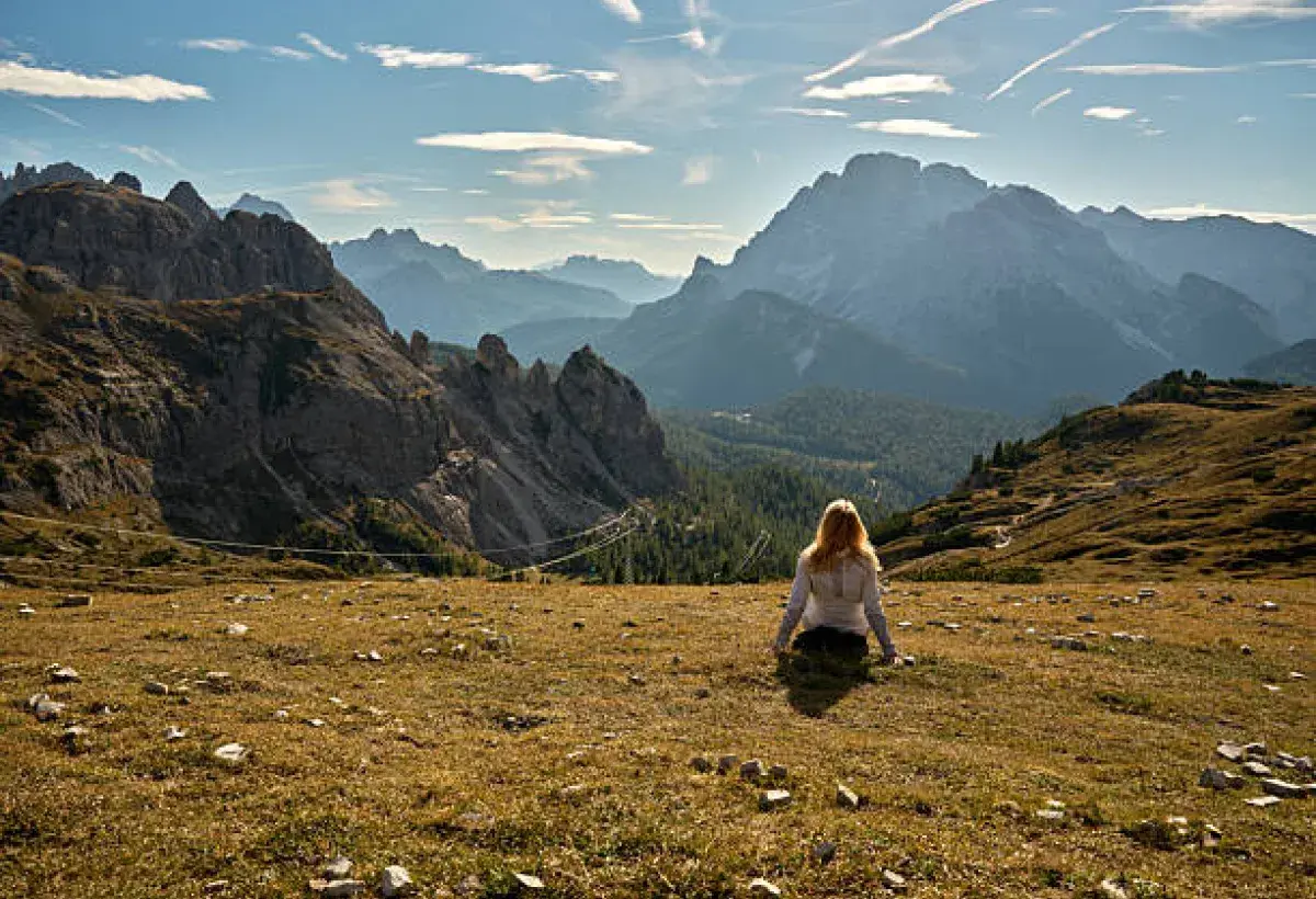 Person sitting quietly in nature, looking out