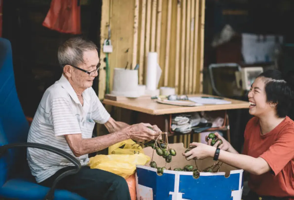Filipino senior receiving assistance in daily work demonstrating resilience and intergenerational support