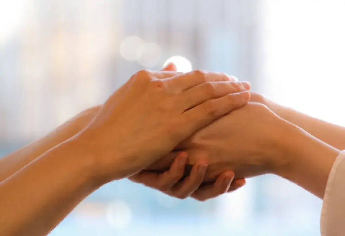 Hands holding each other representing shared burdens and God’s assistance