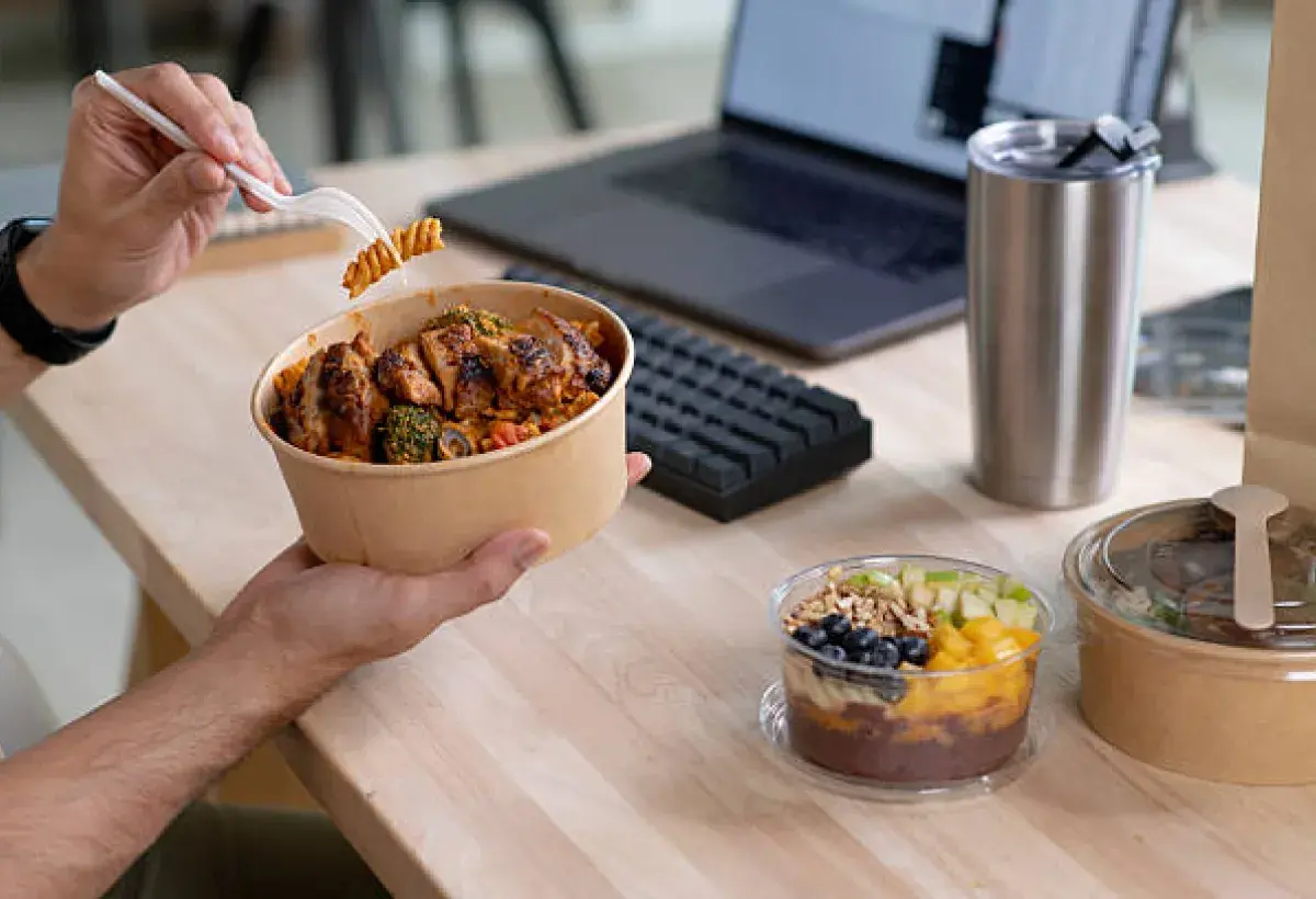 Office employee eating a very large American takeout lunch