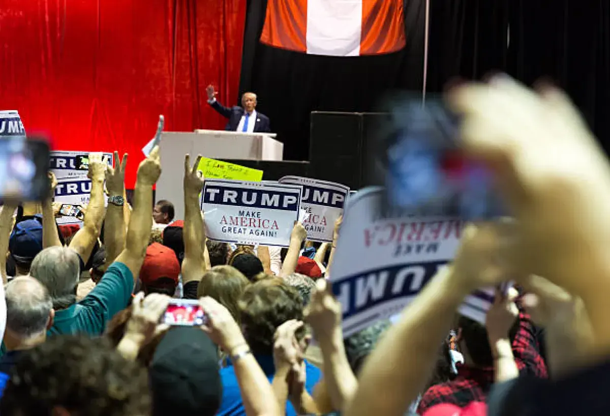 Donald Trump waving to supporters at a rally