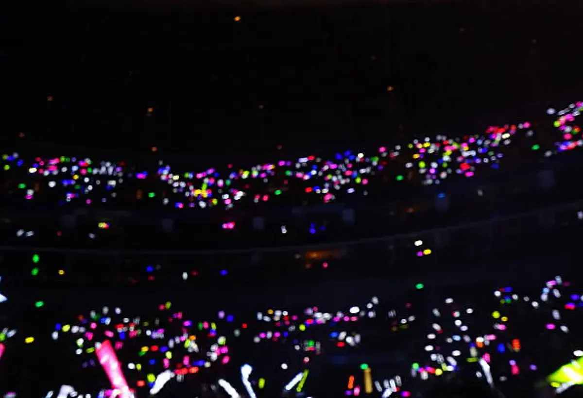 K-pop concert audience forming a sea of glowing lightsticks