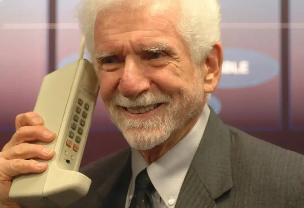 Martin Cooper holding the first handheld mobile phone