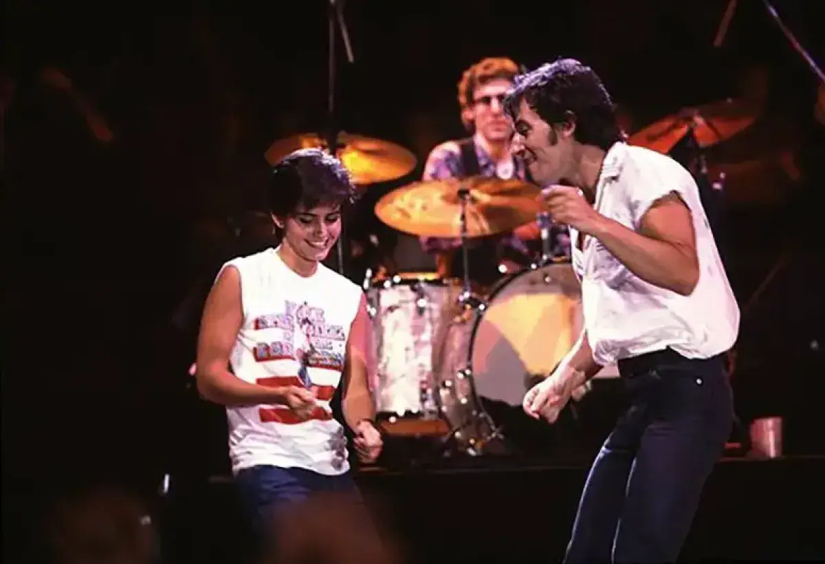 Courteney Cox dancing on stage with Bruce Springsteen