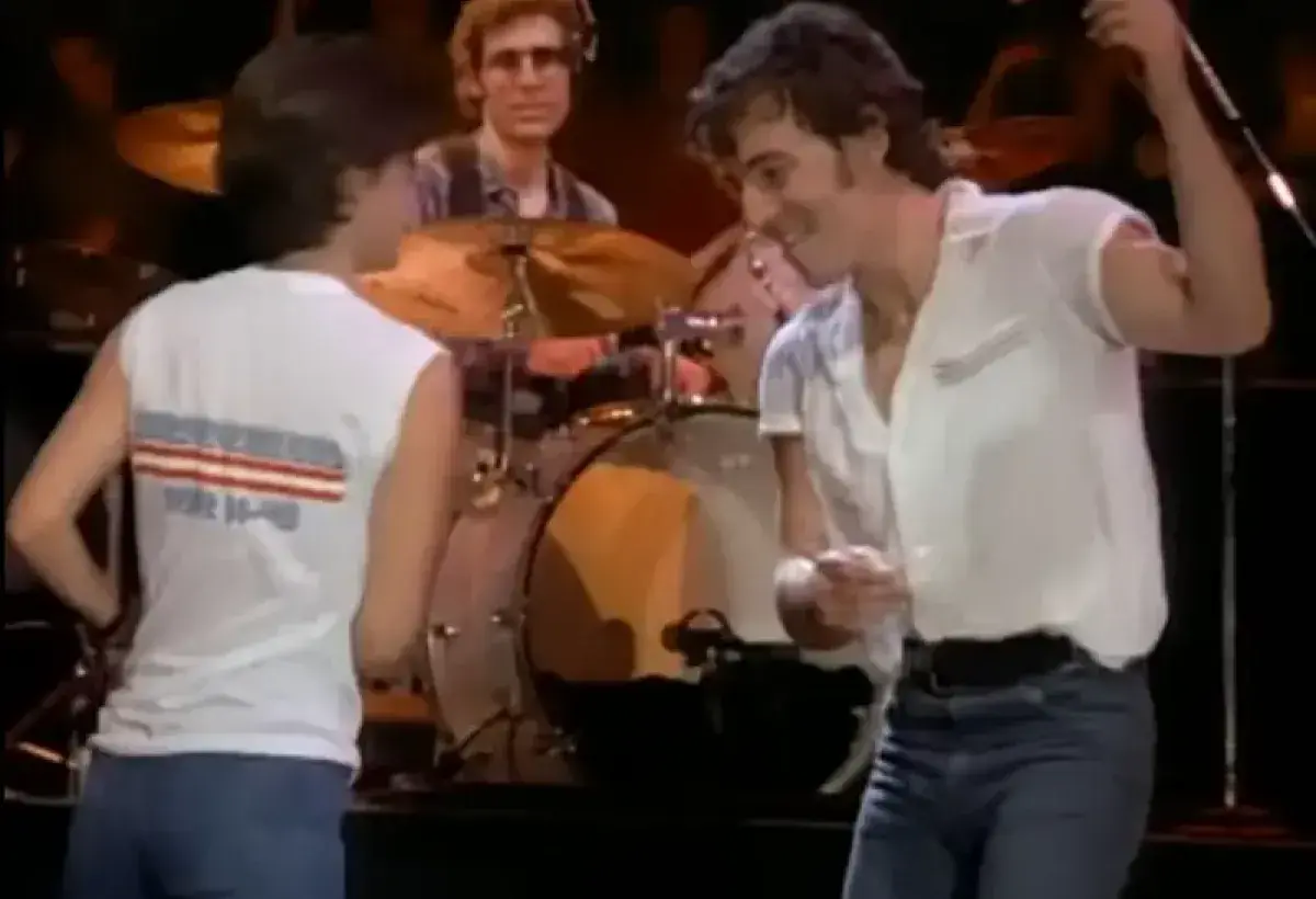 Bruce Springsteen dancing energetically during a live performance