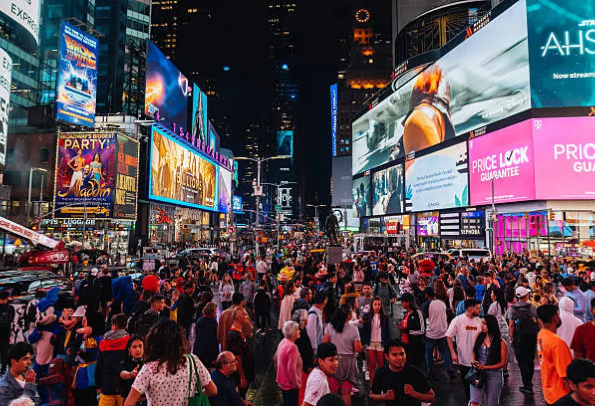Nighttime view of Times Square with neon lights and crowds