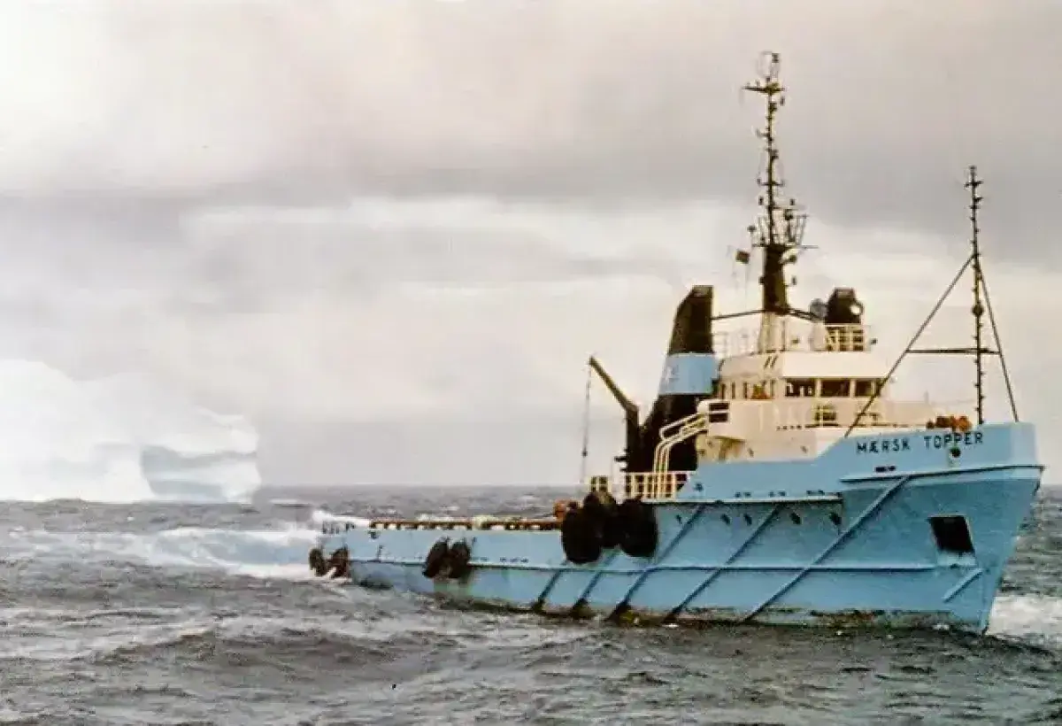 Tugboat guiding an iceberg away from an oil platform