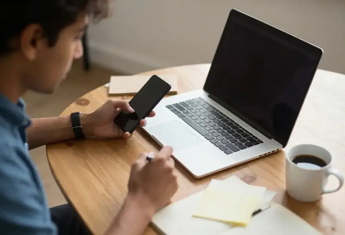 Individual attempting to work while repeatedly checking smartphone