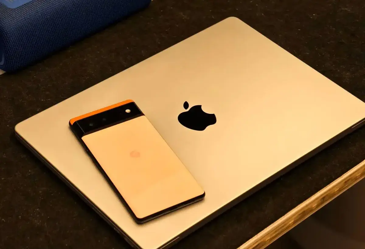 Concept image showing Apple laptop on one side and Android phone on the other representing two ecosystems