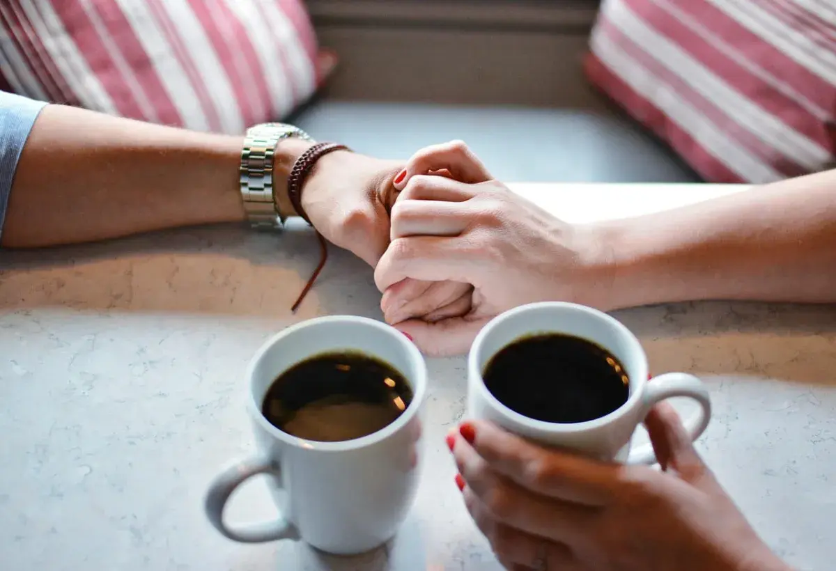 couples hands with cup of coffee 