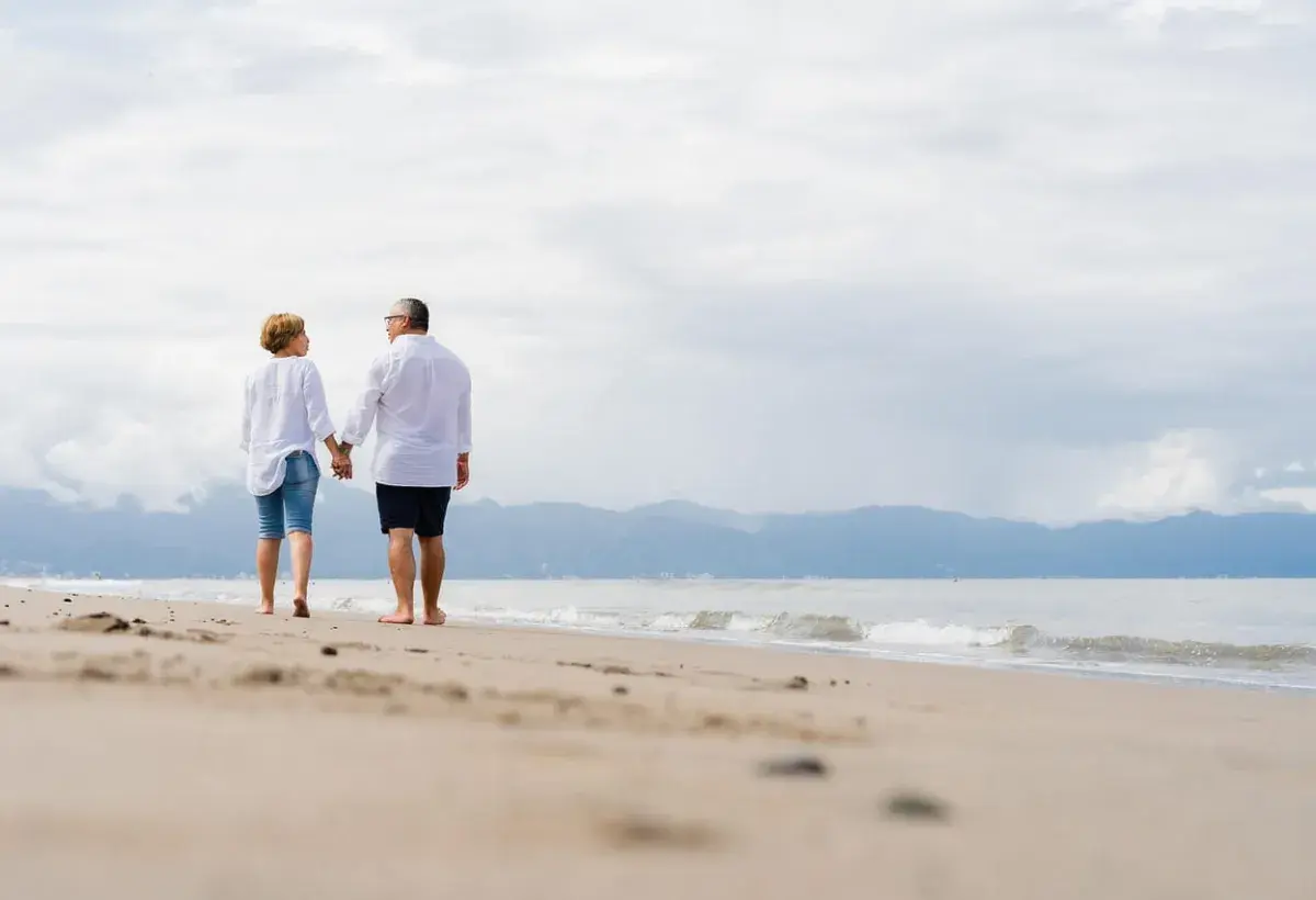 older couple walking at the beach