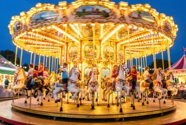 A colorful, spinning vintage carousel with detailed horses and bright lights
