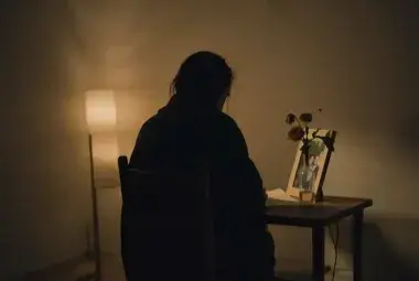 A lone figure sitting in a dimly lit room, symbolizing the quiet regret and loss in Cinderella's power ballad "You Don't Know What You Got Till It's Gone."
