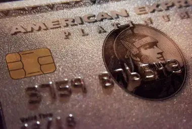 Close-up of American Express Platinum and Gold cards fanned out on a dark marble surface