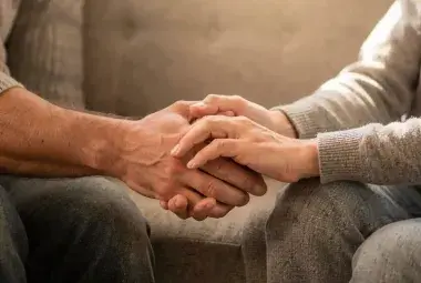 Couple's hands gently holding in a quiet moment of healing and reconnection
