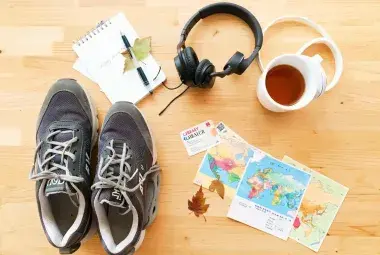 Flatlay of sneakers, notebook, headphones, library card, and small map for weekly adventures