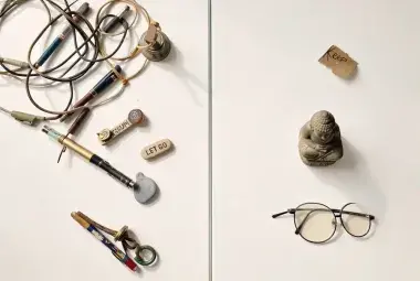 Minimalist flat-lay photograph illustrating the Zen art of decluttering, with a Buddha statue and divided items representing what to keep and what to let go