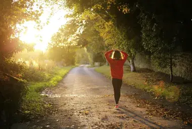 A solitary figure walking on an empty road 