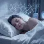 A person sleeping peacefully on a silk pillowcase in soft moonlight, with faint, luminous overlays of collagen and melatonin molecules, representing the science of beauty sleep and overnight skin repair